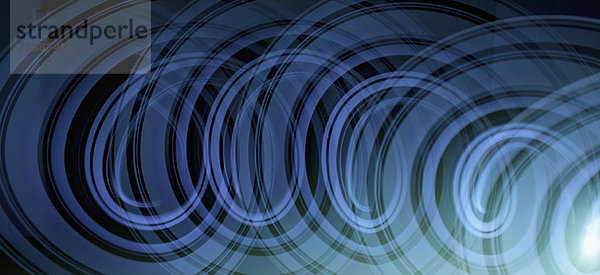 Lichtspuren  die ein abstraktes blaues Spiralmuster auf schwarzem Hintergrund erzeugen.