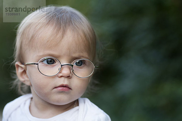 Ein junges Mädchen  das eine Brille trägt  runzelt die Stirn und schaut weg.