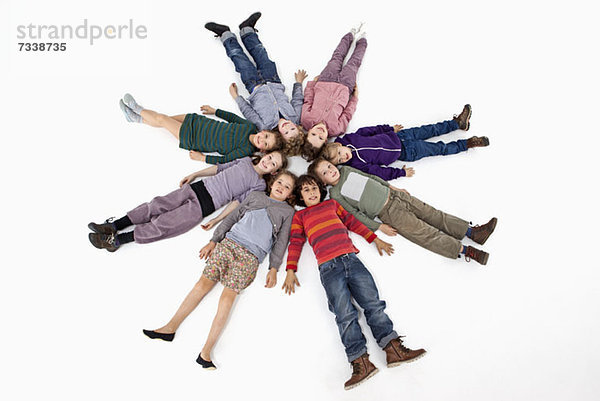 Eine Gruppe von Kindern  die im Kreis auf dem Rücken liegen.
