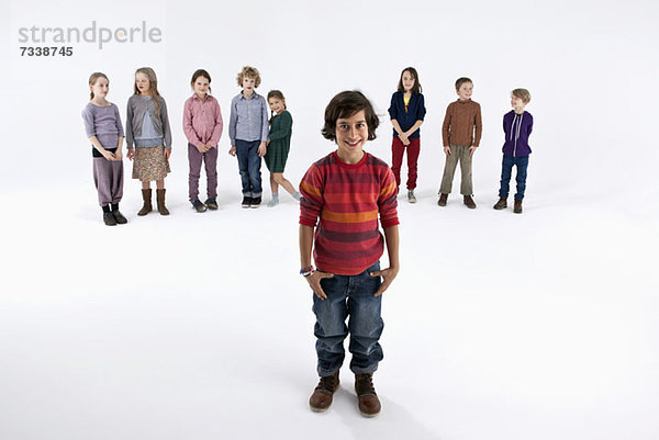 Ein Junge steht vor einer Reihe von Kindern.