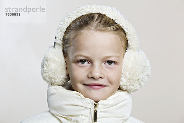 Ein Mädchen mit Ohrenschützern und Winterjacke