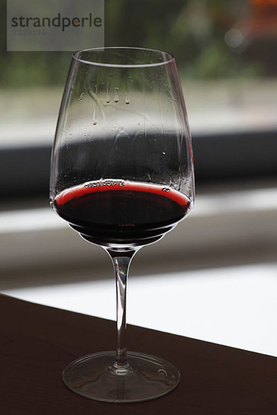Ein Glas Rotwein mit Weinbeinen