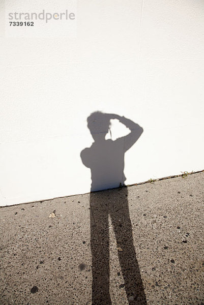 Schatten des Fotografen gegen Boden und Wand