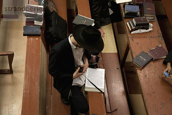 Jüdischer Mann mit Tefillin in der Synagoge