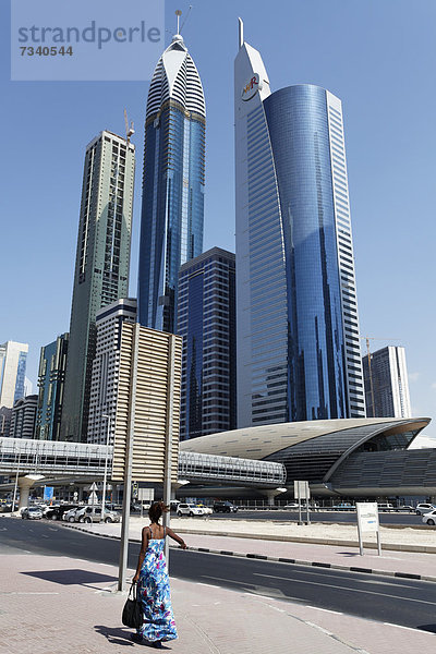 Einzelne Fußgängerin vor Wolkenkratzern  Sheikh Zayed Road  Dubai International Financial Centre  DIFC  Dubai  Vereinigte Arabische Emirate  Naher Osten  Asien