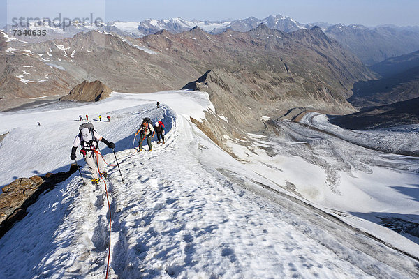 Wanderer auf dem Grat  beim Aufstieg zum Similaun auf dem Niederjochferner im Schnalstal  hinten der Marzell-Kamm  Südtirol  Italien  Europa