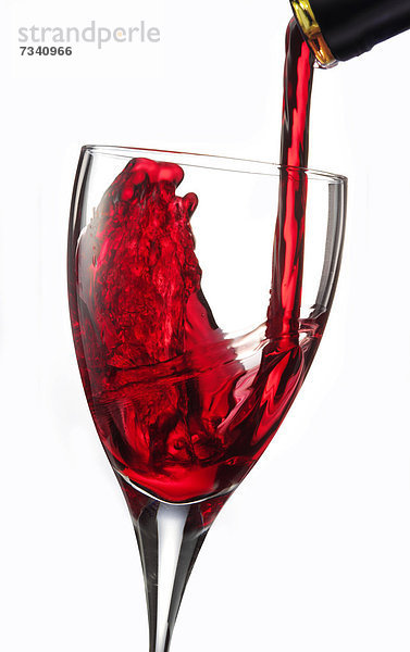 Rotwein wird in ein Glas gegossen