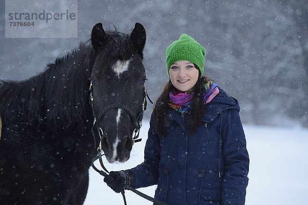 Junge Frau mit Arabohaflinger im Schnee  Oberpfalz  Bayern  Deutschland  Europa