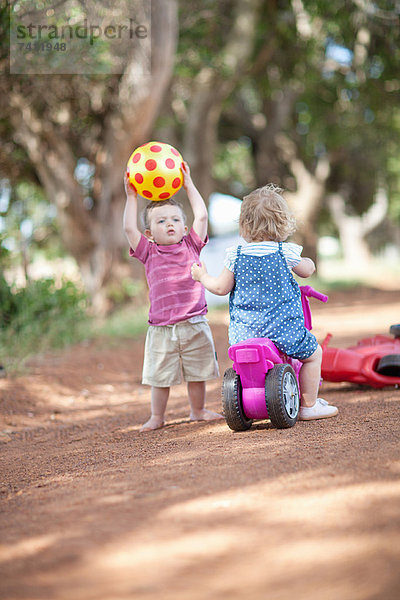 Kleinkinder beim gemeinsamen Spielen auf dem Feldweg