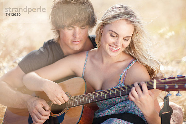 Paare spielen Gitarre zusammen