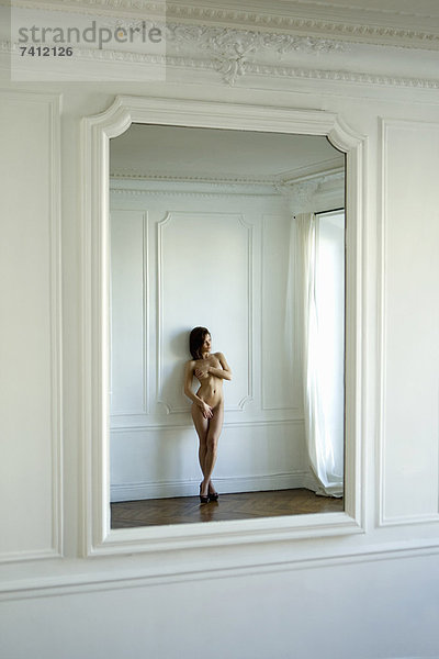 Nackte Frau reflektiert im Spiegel