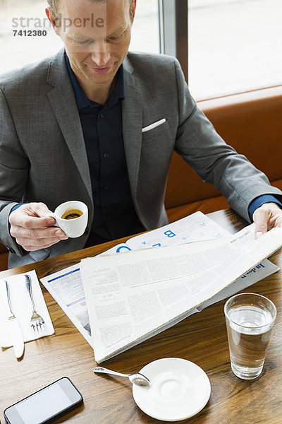 Geschäftsmann beim Lesen im Café