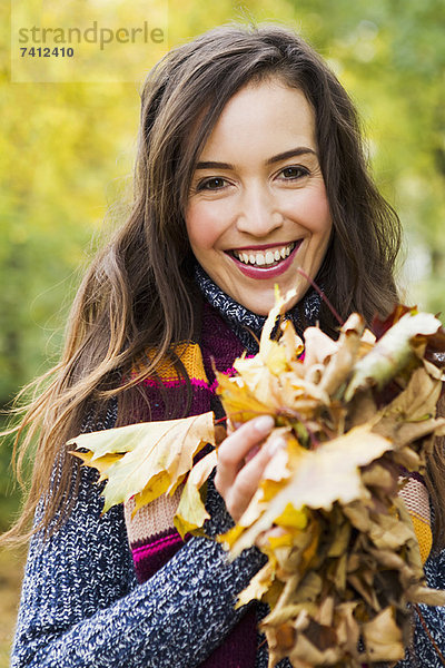 Lächelnde Frau mit Herbstblättern