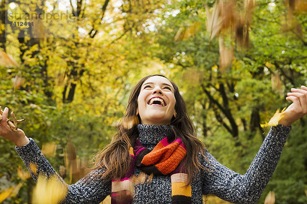 Frau spielt im Herbstlaub