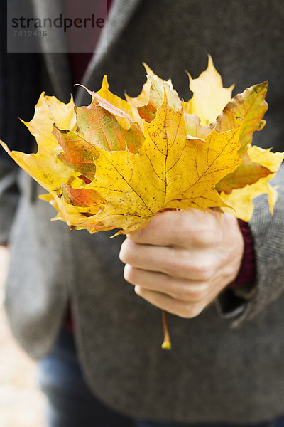 Nahaufnahme eines Mannes mit Herbstblättern