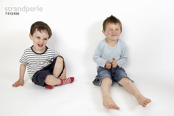 Jungen lächeln zusammen auf dem Boden