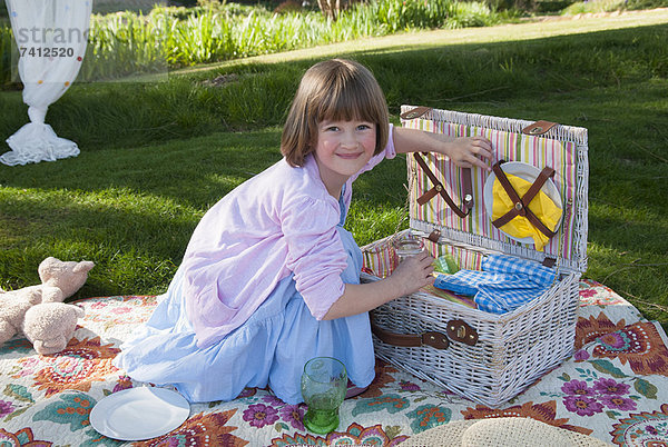 Mädchen beim Auspacken des Picknickkorbes im Feld