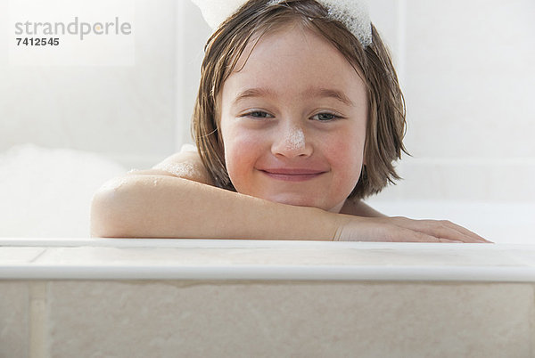 Lächelndes Mädchen sitzt im Bad