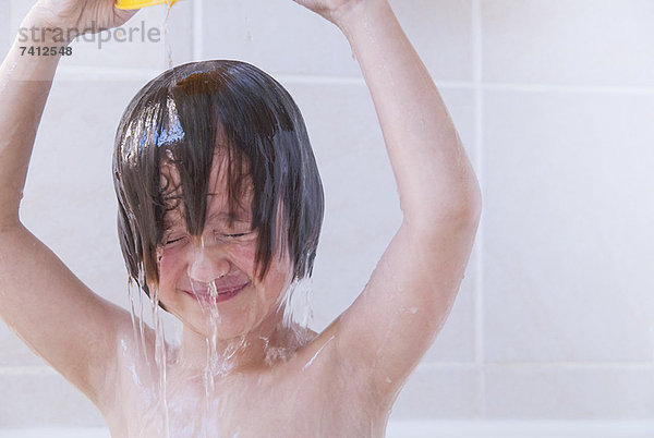 Mädchen wäscht sich die Haare im Bad