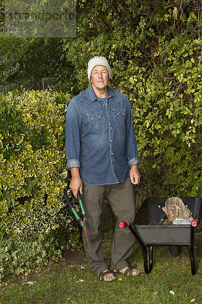 Älterer Mann  der im Garten arbeitet