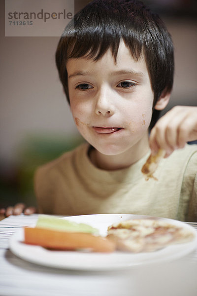 Junge beim Essen am Tisch