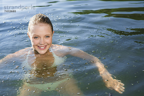 Lächelnde Frau im See schwimmend