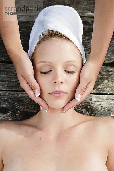 Frau mit Massage auf Holzdeck