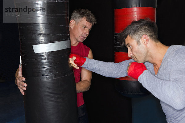 Boxer bei der Arbeit mit dem Trainer im Fitnessstudio