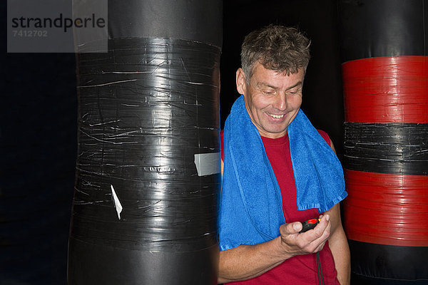 Mann liest Stoppuhr in der Turnhalle