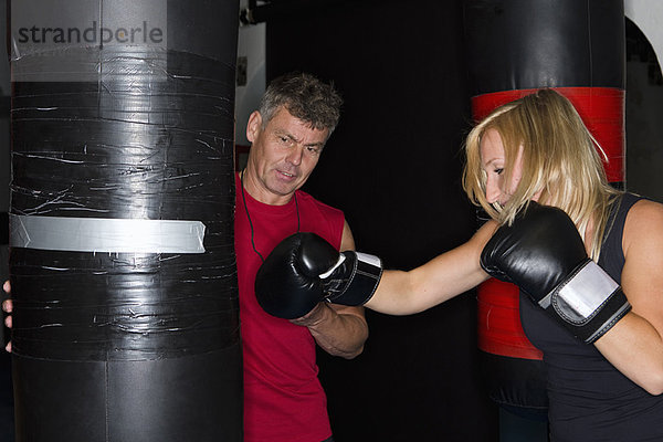 Boxer bei der Arbeit mit dem Trainer im Fitnessstudio