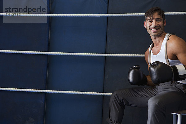 Lächelnder Boxer im Ring sitzend