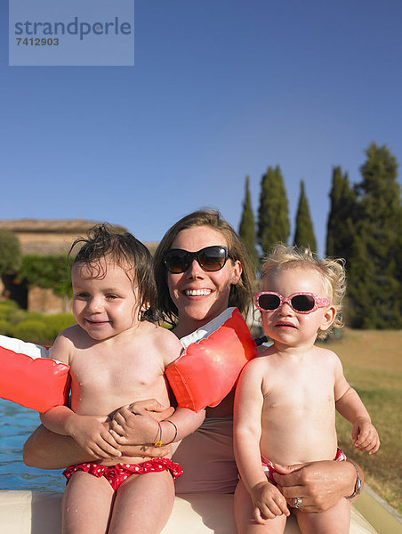 Mutter mit Töchtern am Pool