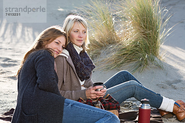 Lächelnde Frauen entspannen sich am Strand