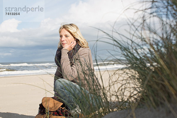 Frau am Strand sitzend