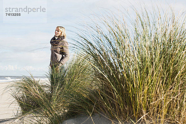 Frau am Strand stehend