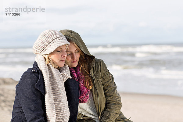 Frauen entspannen gemeinsam am Strand