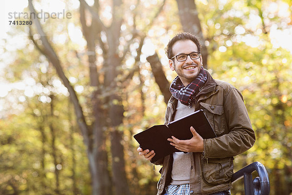 Mann mit Tablet-Computer im Wald