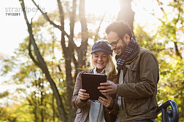 Paar mit Tablet-Computer im Wald