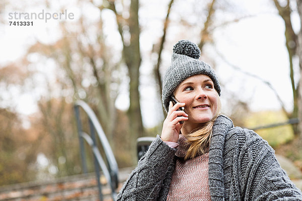 Frau spricht am Handy im Park