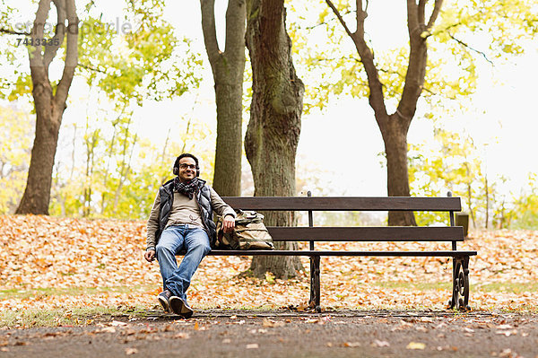 Lächelnder Mann auf Parkbank sitzend