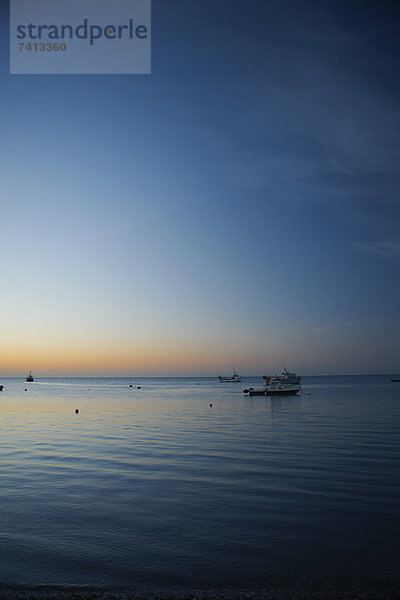 Boote auf ruhigem Wasser bei Sonnenuntergang