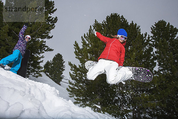 Snowboarder springen auf verschneiter Piste