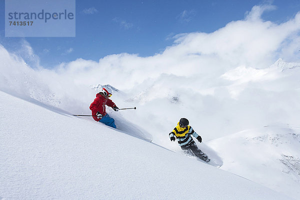 Skifahrer und Snowboarder auf verschneiter Piste