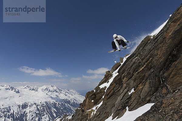 Snowboarder springen auf felsiger Piste
