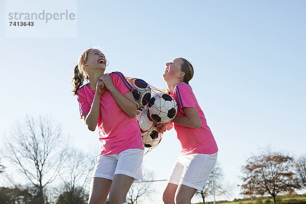 Fußballspieler mit Bällen im Feld