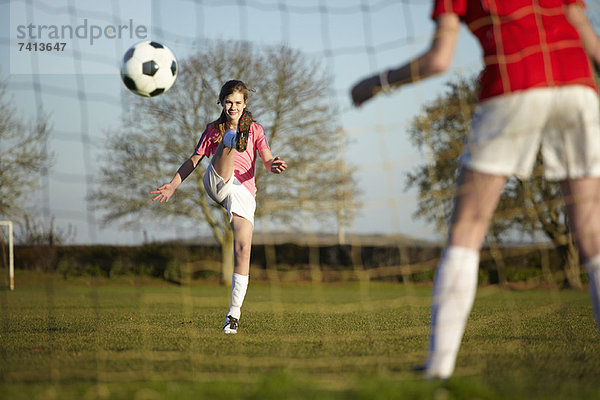 Mädchen tritt Fußball ins Tor