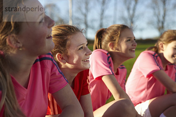 Fußballmannschaft lächelt zusammen im Feld