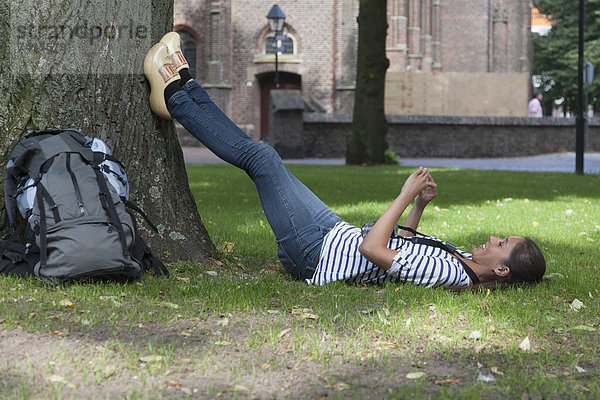 Rucksack  liegend  liegen  liegt  liegendes  liegender  liegende  daliegen  Frau  jung  Gras