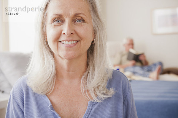 Senior  Senioren  Frau  lächeln  Hintergrund  Ehemann  vorlesen