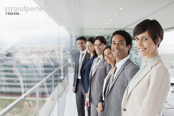 Portrait von lächelnden Geschäftsleuten am Fenster im Konferenzraum